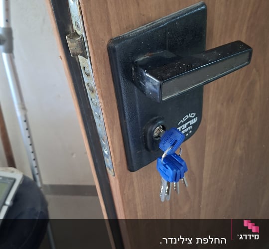 דלת עם מנעול ומפתחות כחולים תלויים
